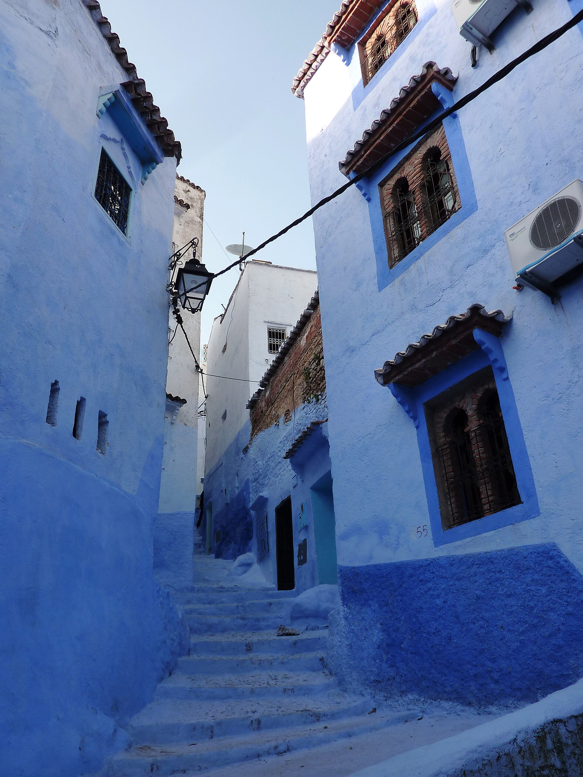 A narrow blue-washed alley in the Chefchaouen medina, walls and steps painted in shades of blue