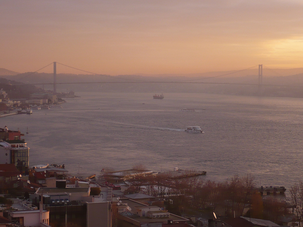 The Bosphorus and the bridge seen between buildings from Cihangir at sunset
