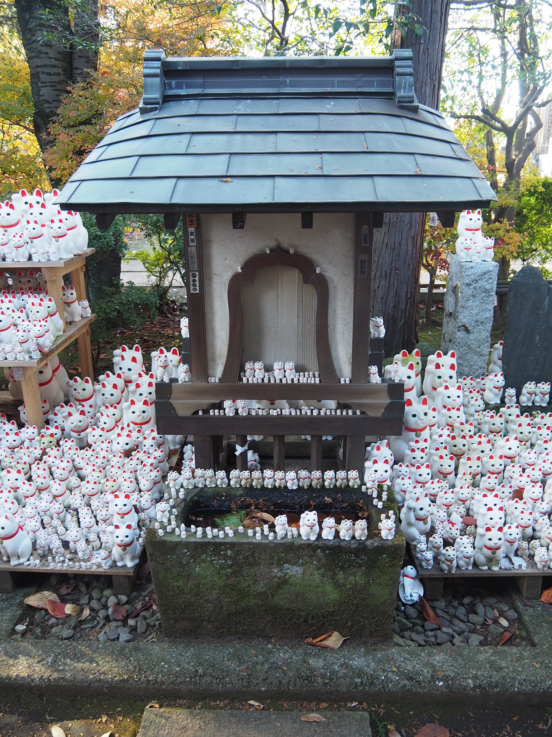 The tiers of maneki-neko figurines beside the shrine at Gotokuji
