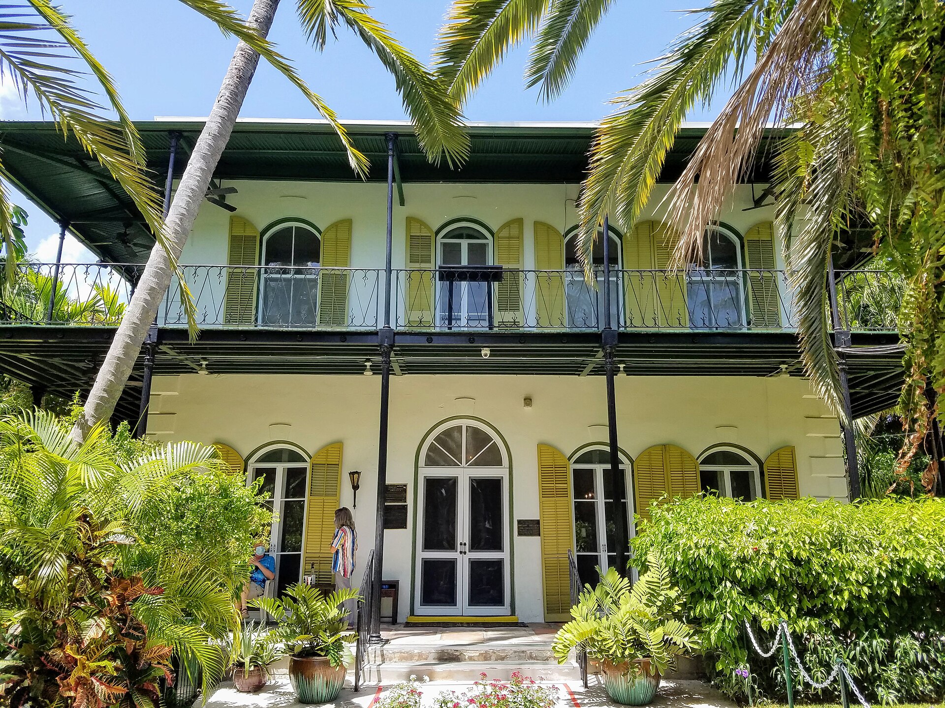 The Ernest Hemingway Home in Key West, a two-storey Spanish colonial house with green shutters and a wraparound veranda among palms