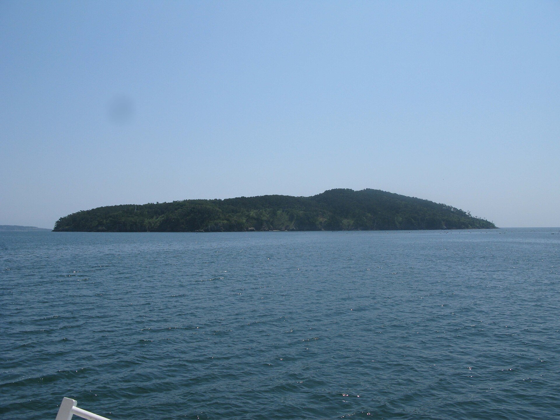 Tashirojima seen from the water, low, green and wooded