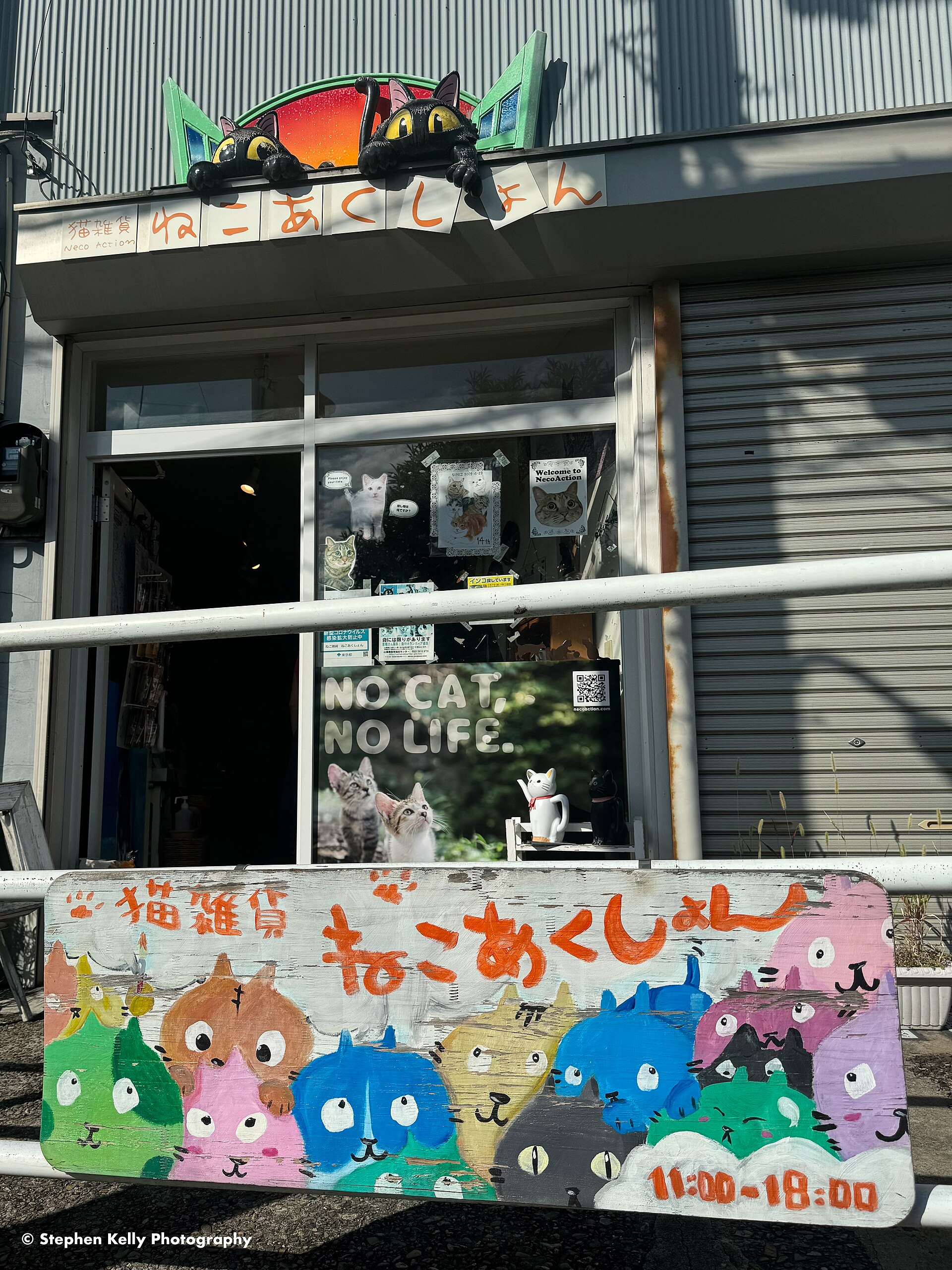 The Neco Action cat goods shop on Yanaka Ginza, with a hand-painted sign of cartoon cats and a poster reading No Cat, No Life